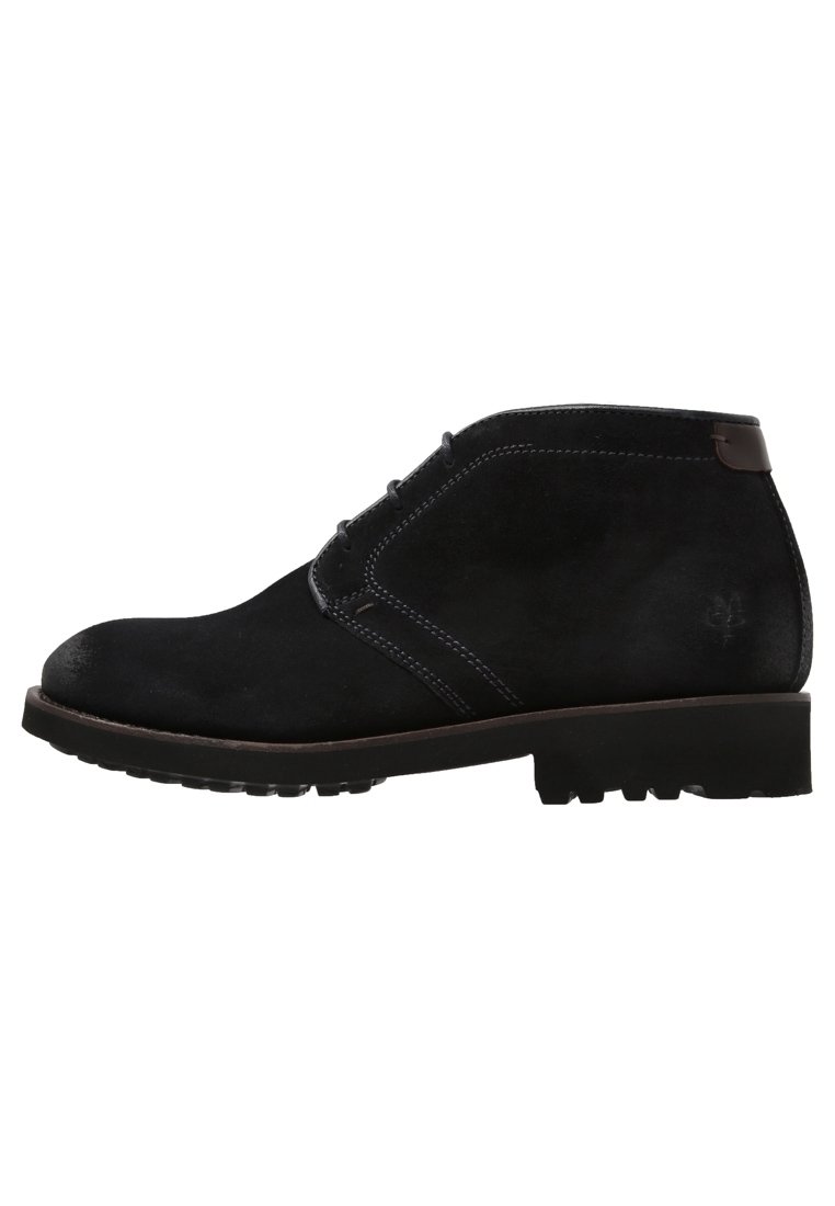 Stivaletti alla caviglia in suede nero con finitura liscia, punta tonda, design con lacci e dettagli in pelle marrone sul colletto e sulla suola.