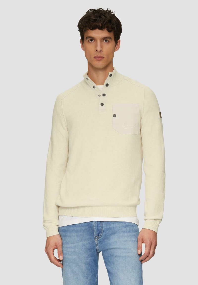 Off-white gebreide pullover met een hoge kraag, knoopsluiting en een borstzak. Heeft ribgebreide manchetten en zoom, met subtiele stikdetails.