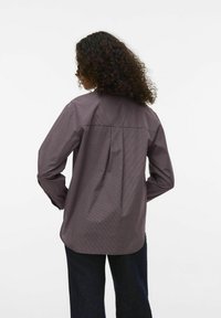 Bordeaux geruite blouse met lange mouwen, een relaxte pasvorm, achterplooidetail en afgeronde zoom. Katoenmix stof met een soepele textuur.