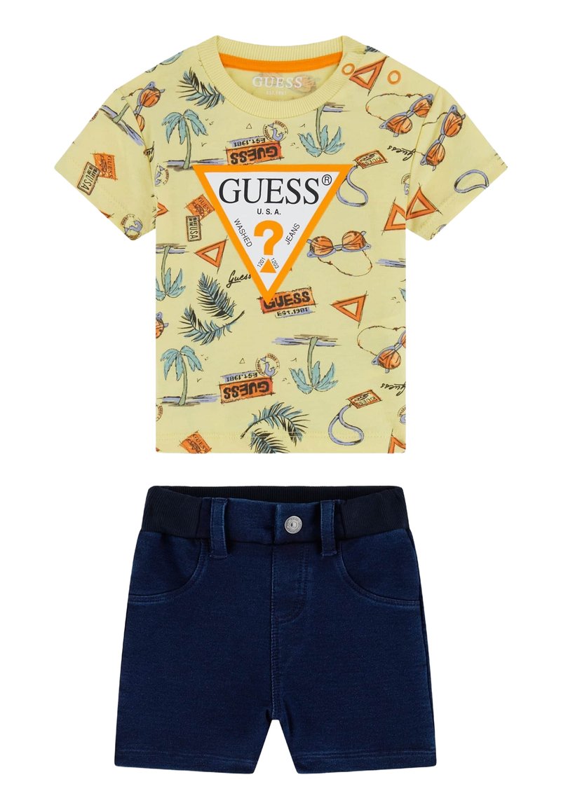 T-shirt graphique jaune avec imprimés de palmier et de basket-ball, associé à un short en denim bleu marine avec une taille élastique et un bouton.