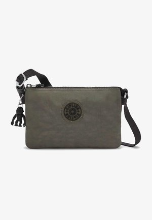 Kleine schoudertas in olijfgroen met een zwarte verstelbare band, een ronde logo patch, ritssluiting en een zwarte sleutelhanger met een aapje.