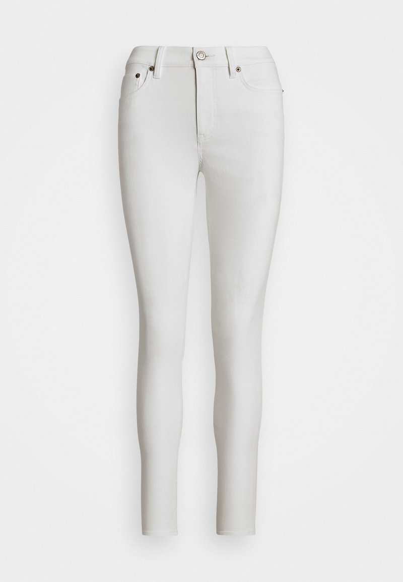 Jeans skinnys blancos de denim, con una cintura alta, cinco bolsillos y detalles en metal dorado.