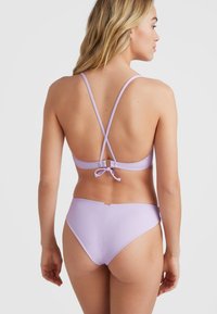 Sofijos bikini komplektas su kryžminiais petnešomis, reguliuojama kaspino uždanga ir sklandžiu, elastingu audiniu su minimalizmo elementais.