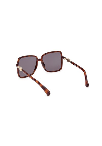 Gafas de sol carey marrón con grandes lentes cuadrados, tintado gris oscuro y patillas elegantes con acentos metálicos.