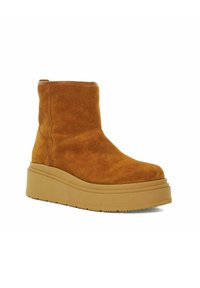 Suède enkellaars in mosterdgeel met een chunky platformzool. Heeft een afgeronde neus en minimale stikdetails. Gladde leren afwerking.