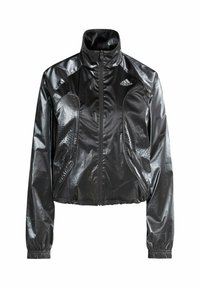 Czarna, błyszcząca kurtka typu cropped z wysokim kołnierzem, zapinana na zamek, z bocznymi kieszeniami i perforowanymi detalami. Na piersi znajduje się logo adidas.