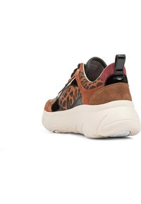 Sneaker con stampa leopardata marrone e nera, con accenti in suede e pelle verniciata, suola spessa color crema e lacci neri. La parte posteriore presenta una linguetta rossa.