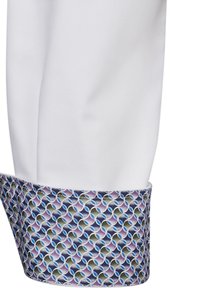 Manica di giacca da cuoco bianca con un polsino decorato da cerchi intrecciati in toni di blu, viola e grigio, realizzato in tessuto morbido.