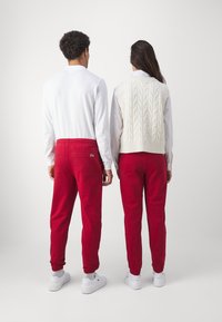 Lacoste SUBTLE LOGO TRACKPANT UNISEX  - Treningo apatinė dalis - ora