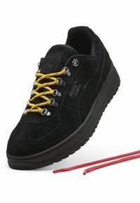 Zwarte suède sneakers met heldergele veters, zilveren oogjes en een gestructureerde zool. Rode veters zijn ook inbegrepen.