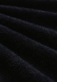 Dunkelblauem Stoff mit einer weichen, plüschigen Textur, der subtile Rillen und eine leicht fuzzy Oberfläche aufweist.