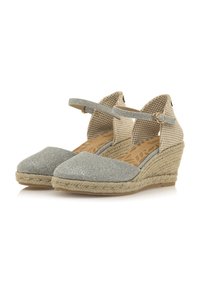 Espadrillas con zeppa, in tessuto argentato scintillante, e cinturini alla caviglia in tessuto intrecciato beige. Presentano una suola avvolta in juta e una soletta decorata.