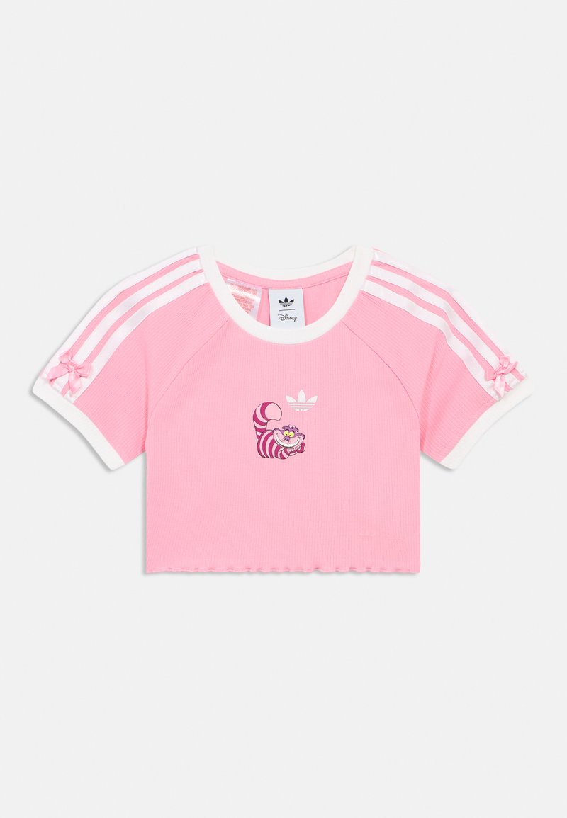 Tricou roz scurtat cu textură nervurată, accente albe și dungi roz și albe Adidas. Prezintă un design imprimat cu Pisica Cheshire.