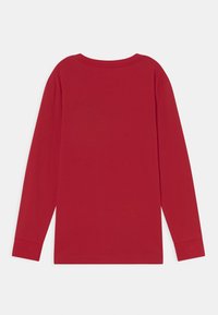Rød langærmet skjorte vist fra ryggen med rund halsudskæring og et simpelt, ensfarvet design.