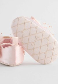 Pantofi roz din satin pentru bebeluși, cu o talpă din cauciuc texturată, având un accent din tul și detalii cu puncte. Include un mic tab pentru călcâi pentru o purtare ușoară.
