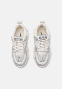 Baskets blanches avec des accents argentés, tige en mesh texturé et rhinestones décoratifs. Comprend un col rembourré et un système de laçage.