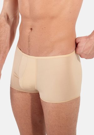 Shorts de sport beiges en tissu doux et extensible. Présentent un design ajusté et des coutures contrastées. Conviennent pour une utilisation active.