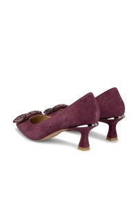 Purple suede heels with a pointed toe, featuring decorative sequined accents and a short, tapered heel with a contrasting black detail.