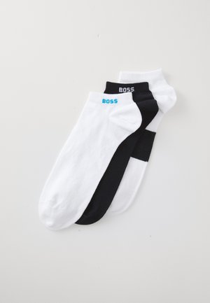 Trois paires de chaussettes mi-mollet en coton noir et blanc. Chaque chaussette arbore le logo "BOSS" en couleurs contrastées sur le bord.