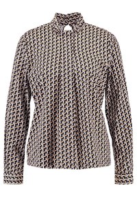 Blusa a maniche lunghe con colletto alto, caratterizzata da un motivo geometrico nei colori crema, marrone e nero. Tessuto leggero con una texture liscia.