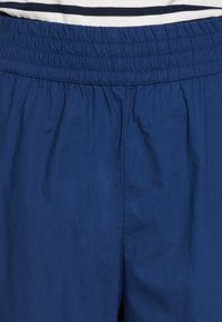 Elastieke tailleband shorts gemaakt van effen marineblauwe stof, met een zachte textuur en een eenvoudig ontwerp met een kleine plooidetail.