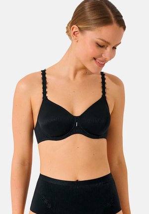 Soutien-gorge noir avec des bonnets sans couture, tissu texturé, bretelles décoratives avec accents, et un petit fermoir en argent au centre devant.