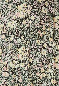 Tecido floral com fundo preto, apresentando pequenas flores em tons pastéis de amarelo, rosa e verde, com textura plissada e caimento suave.
