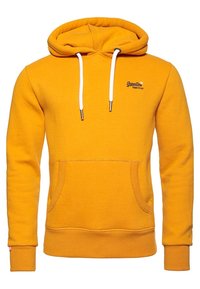 Sudadera amarilla hecha de tela suave, que cuenta con un bolsillo frontal tipo pouch, capucha con cordón y parche de logo en el pecho. Cordones blancos y puños acanalados.