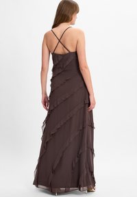 Braunes Chiffon-Maxikleid mit geschichteten Rüsche, Spaghettiträgern und rückenfester Kreuzdesign. Fließende Silhouette mit einer glatten Textur.