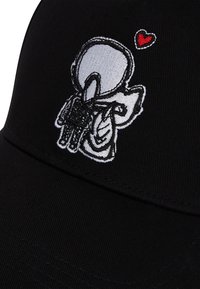 Șapcă de baseball neagră cu un design brodat al unui personaj care ține un obiect alb cu o inimă roșie, evidențiind o țesătură texturată.