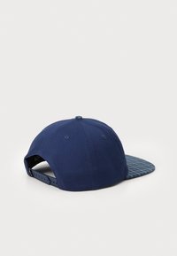 Mørkeblå baseballcap med en mønstret mørkeblå skygge, lavet af stof, med snapback-lukning og syninger på krone.