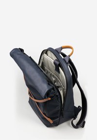 Zaino blu navy con dettagli in pelle, dotato di chiusura a rotolo e un ampio interno con fodera chiara e molteplici tasche.