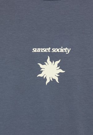 Soare stilizat alb cu raze unduitoare sub expresia „sunset society” pe un fond simplu dintr-un material albastru închis.