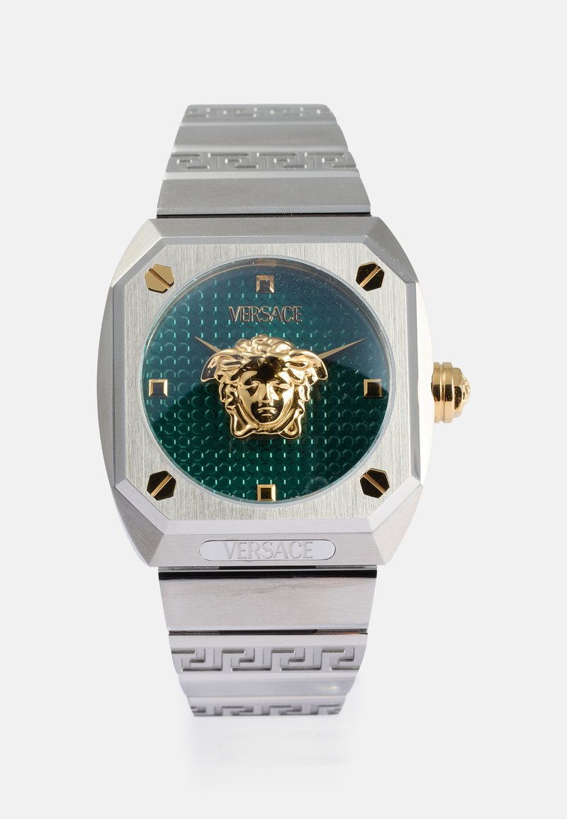 Ρολόι Versace με οκταγωνιαία ασημένια θήκη, πράσινο μοτίβο στην κάσα, χρυσό έμβλημα λιονταριού, χρυσές λεπτομέρειες και ασημένιο μεταλλικό βραχιόλι με σχέδιο ελληνικού κλειδιού.