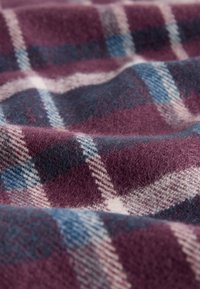 Tessuto di lana a quadri con base color granata, caratterizzato da quadretti azzurri chiari e crema. Texture morbida con una leggera lucentezza e profondità nel motivo.