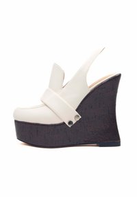 Sandalo wedge bianco in pelle con punta arrotondata, design slingback e una piattaforma scura di tipo sughero testurizzato. Accenti in metallo argentato sulla cinghia.