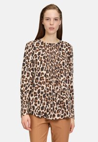 Blusa a maniche lunghe con stampa leopardata nei colori beige, marrone e nero, con pieghe sul colletto e maniche aderenti.