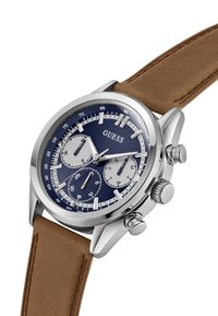 Reloj de acero inoxidable plateado con una esfera azul, tres subesferas y una correa de cuero marrón. Presenta detalles de cronógrafo y taquímetro.