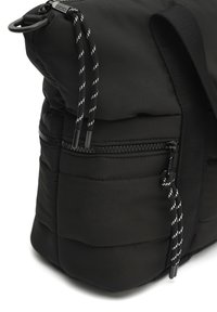 Čierny vystúžený batoh s vreckom na zips, ktorý má textúrovanú látku, kontrastný biely šnúrku s čiernymi akcentmi a pevným popruhom.