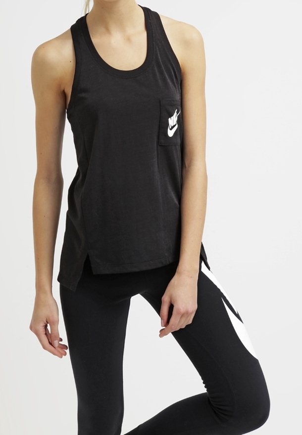Svart ärmlös linne med en framficka som har en vit Nike-logotyp, tillsammans med åtsittande svarta leggings som har en vit swoosh-design.