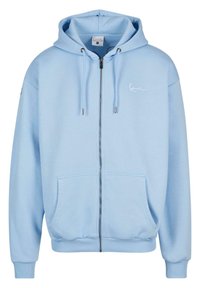 Light blue zip-up hoodie made of soft fabric. Features a hood, front pockets, ribbed cuffs, and hem. Subtle logo detail on the chest.