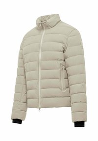 Giacca piumino beige chiaro con colletto alto, tasche laterali e polsini neri. Presenta cuciture orizzontali per l'isolamento.