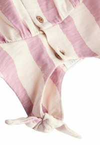 Stribet stof i pink og crème, med træknapper og en knyttet detalje ved kanten. Blødt, struktureret materiale.