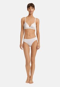 Vit, sömlös bh med tunna remmar och triangulär form, matchande vit högmidjad trosor. Slät textur, minimalistisk design.