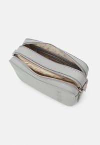 Borsa a tracolla in pelle grigia con superficie texturizzata, due scomparti con zip e una fodera liscia. Presenta il logo impresso sul lato.