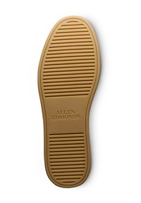 Semelle de chaussure en caoutchouc beige présentant des rainures horizontales et verticales pour une meilleure adhérence, portant l'inscription "ALLEN EDMONDS" au niveau de la partie médiane. Forme plate et ovale.