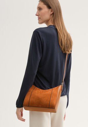 Braune Wildleder- und Ledertasche für den Crossbody-Tragekomfort mit einem schlanken, kantigen Design, das kontrastierende Nähte und einen langen, verstellbaren Trageriemen aufweist.
