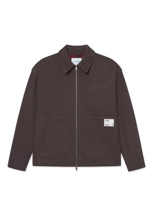 Veste en coton marron avec un col, une fermeture éclair à l'avant, deux grandes poches et une petite poche sur la poitrine. Détail de l'étiquette sur la poche inférieure.