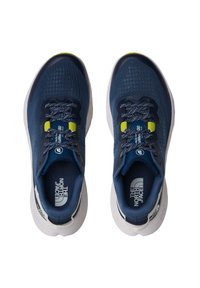 Námořnické modré sportovní boty s texturovaným síťovaným svrškem, zaoblenou špičkou, reflexními tkaničkami a bílou mezipodešví s logovými akcenty.