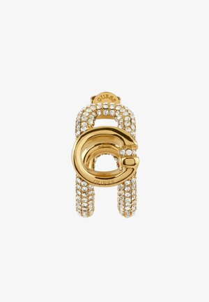 Pendente in tonalità oro con un design circolare, incastonato di cristalli trasparenti. Superficie liscia con dettagli testurizzati. Nome del marchio visibile sulla parte superiore.